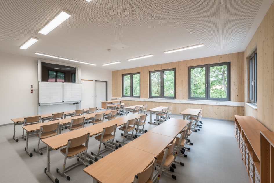 Klassenzimmer mit Betondecke und sichtbarer Holzoberfläche der LENO® -ADD-Außenwandelemente