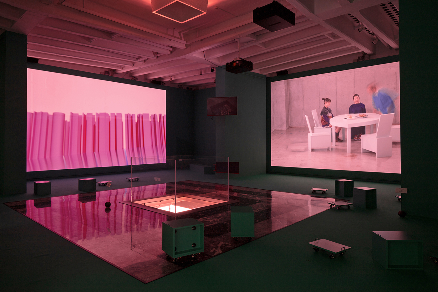 Ausstellungsraum, der im Rahmen einer Videoinstallation zartlilafarbenes Licht getaucht ist.