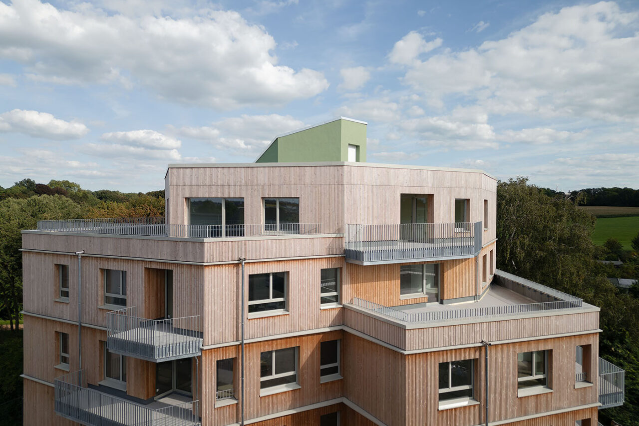 Wohnhaus mit Fassade aus Holz und hellgrauen Balkonen