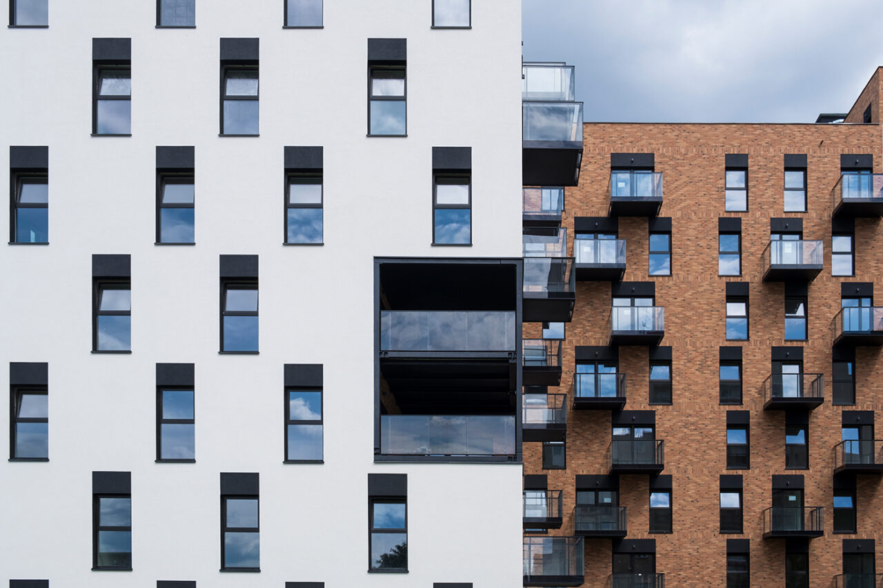 Wohnhäuser mit weiß verputzter Fassade und Ziegelfassade