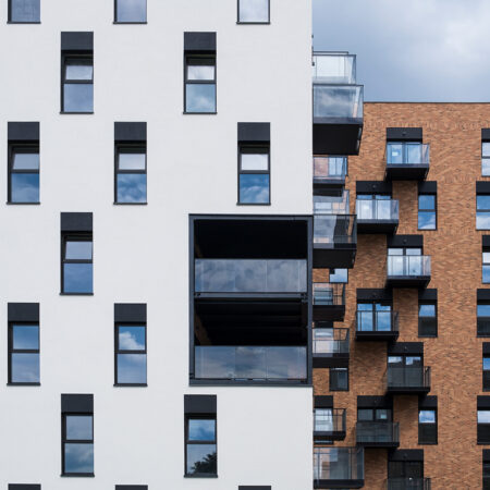 Wohnhäuser mit weiß verputzter Fassade und Ziegelfassade