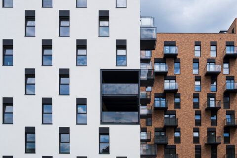 Wohnhäuser mit weiß verputzter Fassade und Ziegelfassade