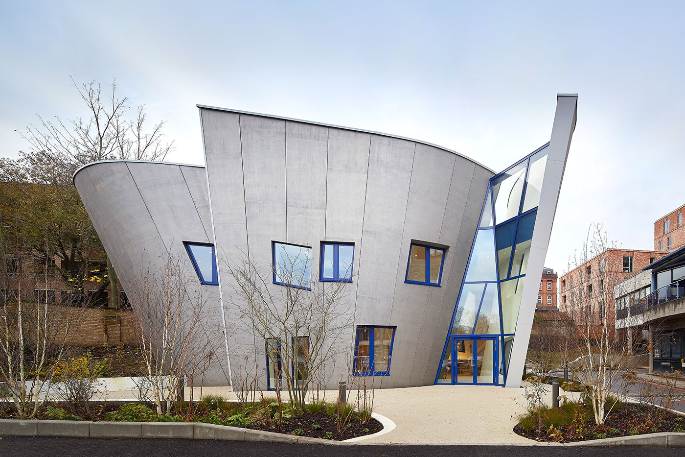 Maggie´s Centre in London: ein Bau, der aussieht, wie ein Trichter, mit hellgrauer Fassade und Fenstern mit blauem Fensterrahmen.